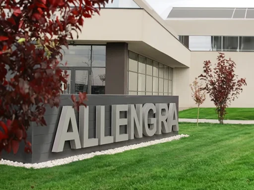 Der Hauptsitz von Allengra in Oradea mit Gras und kleinen Bäumen